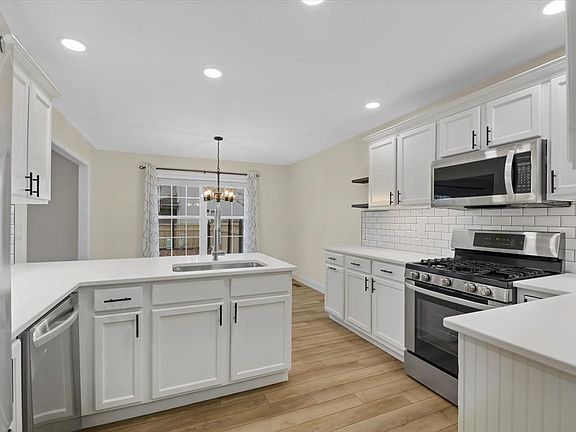 New Lighting and Newly Painted White Cabinets with Wainscoting.