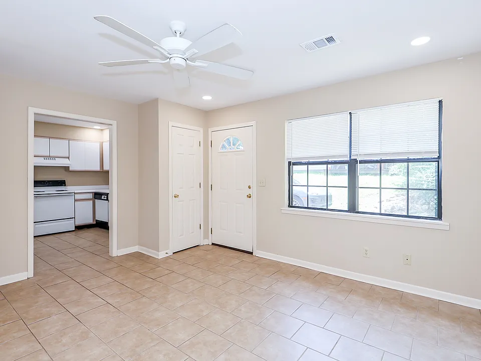 Living room with view toward kitchen and coat closet