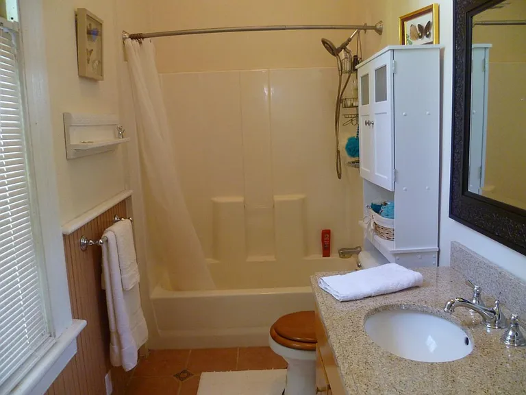 Updated guest bath with granite vanity reclaimed from historic hotel.