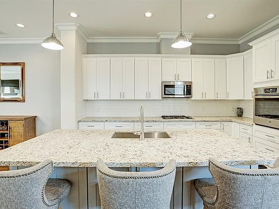 View of the kitchen with stainless steel appliances and a gas cooktop. There is plenty of storage in the Shaker-style cabinets.
