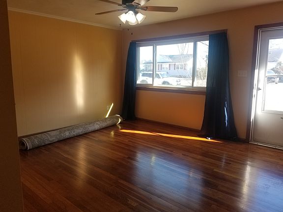 Living room with large window. 
Natural wood flooring in living room.