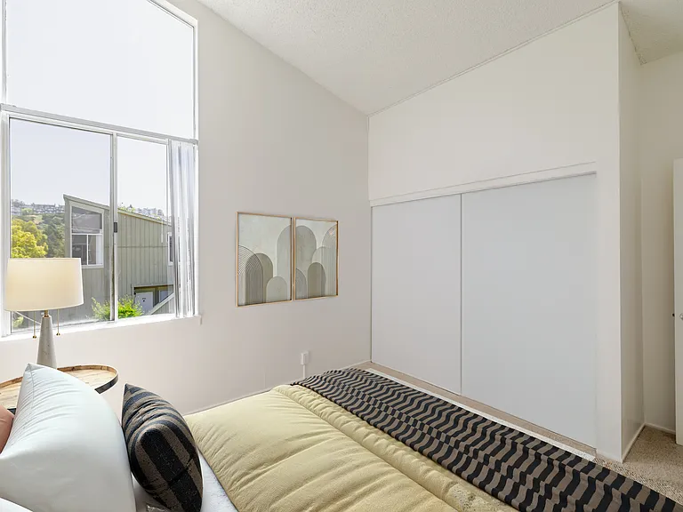 Bedroom B features tall ceilings and large windows.