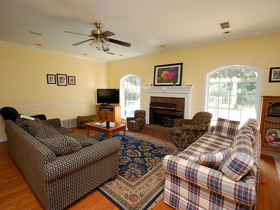 Bright and cheery living room with a fireplace and a view to the pool!