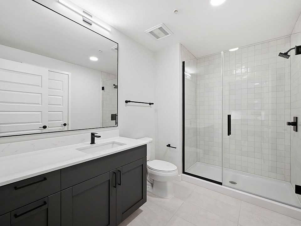 Bathroom with large vanity and glass tiled shower