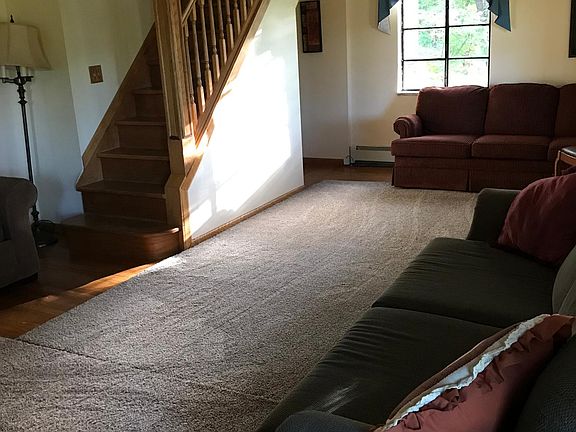 Living room comfortably furnished with warm neutral colors and lots of space to sit or stretch out.