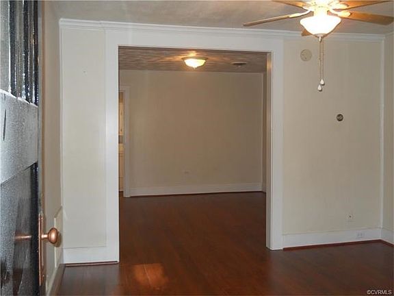 Spacious living room and dining room areas. Note high ceilings and pretty plaster!