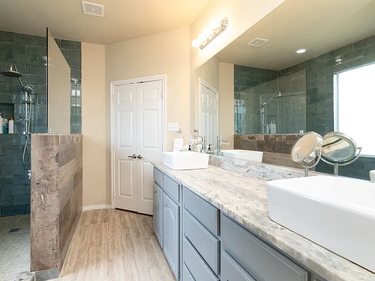 Spacious bathroom attached to the primary bedroom with double sinks, large mirror, and ample counter space. Convenient access to the walk-in closet. Bright, clean, and easy to get ready in.