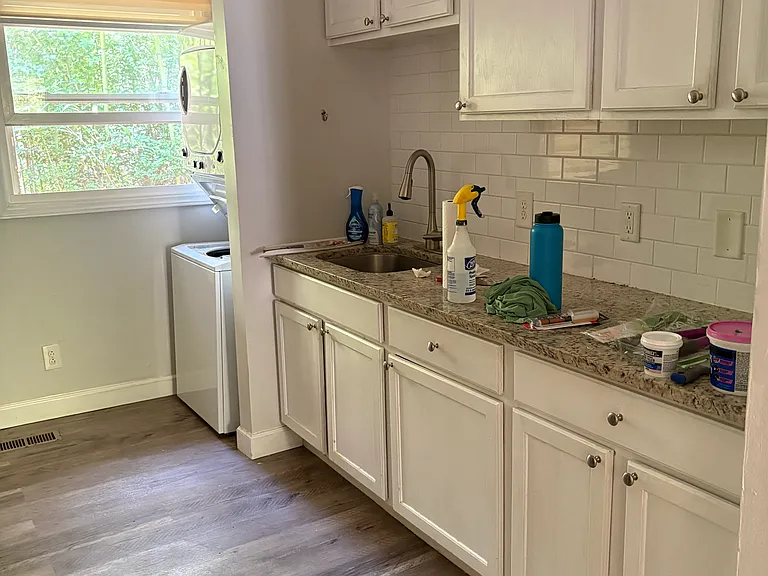 view of kitchen counter, washer/dryer stack at end next to window