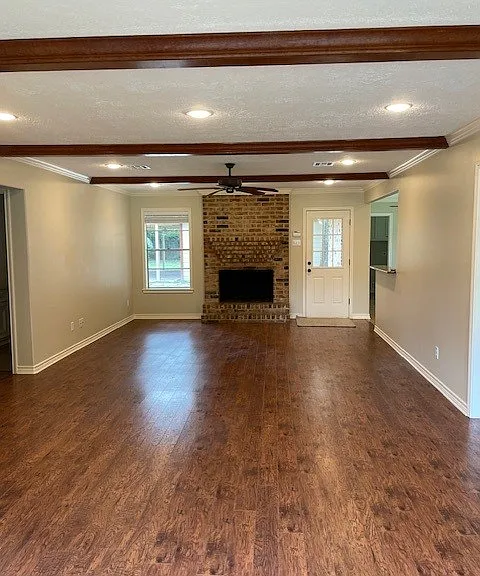 Family room with fireplace and door to back yard. Laminate flooring. Bedrooms are to the left and kitchen/dining to the right.