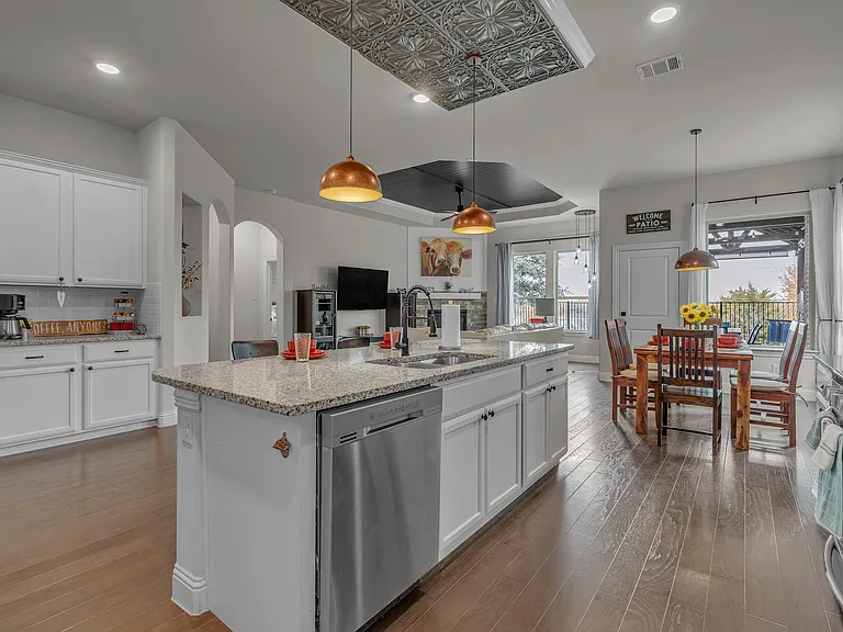 View of kitchen open to the family room, dining area, and windows with lake views on the back.