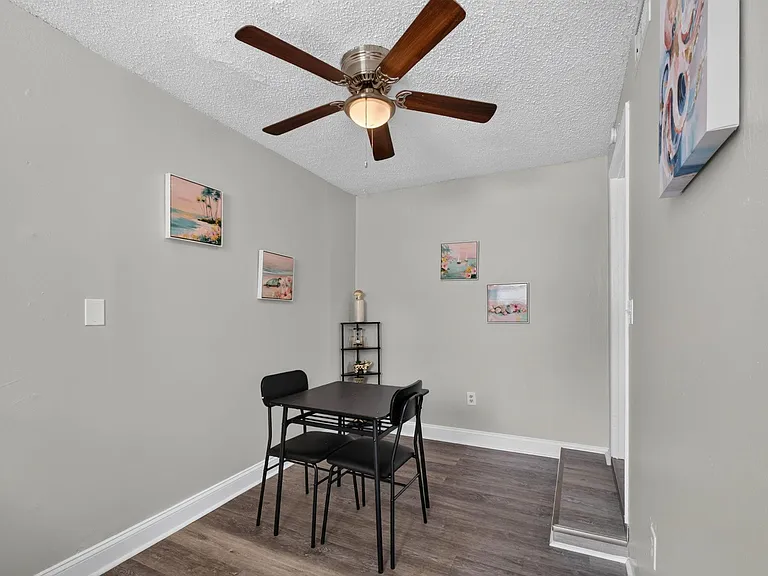 Dedicated dining nook with a table for two, ceiling fan with light, and durable flooring for easy everyday use.