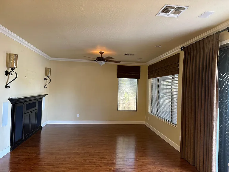 Living room has a built in entertainment center with custom valances and sliding door drapes!