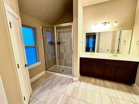 Elegant master bathroom with dual sinks, walk-in shower, and plenty of natural light _ a bright, relaxing space to start and end your day.