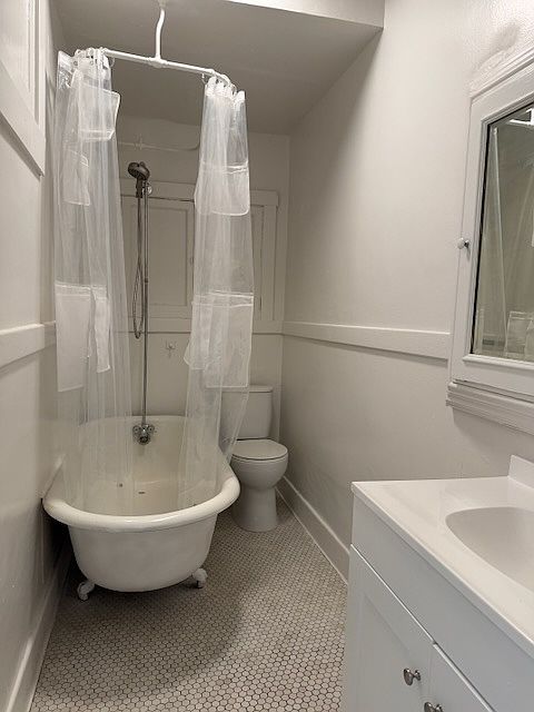 Full size bathroom with shower over clawfoot tub and toilet, plus sink, mirror cabinet and bathroom storage