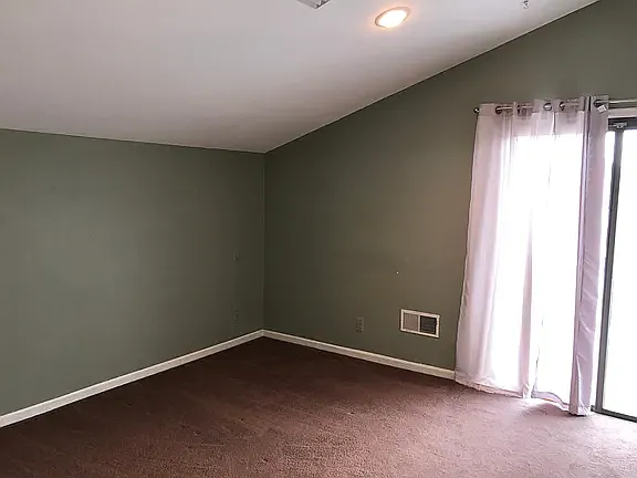 Comfortable secondary bedroom with private upper deck access and ample closet space.