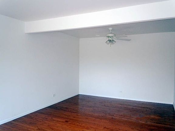 Living and Dining Area with Crisp White Walls and Hardwood Flooring