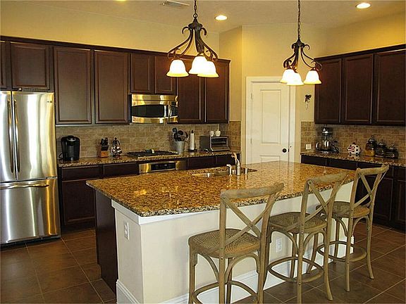 Gourmet island kitchen features granite counter tops, stainless steel appliances, and recessed light