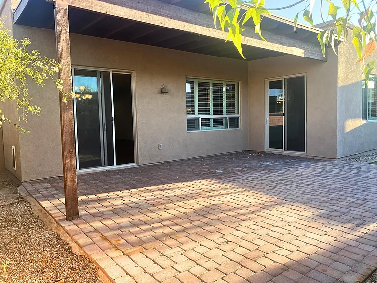 Expansive paver patio with both covered area with new lighted fan and uncovered areas.