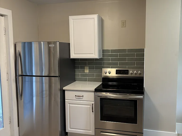 Kitchen - brand new cabinets, tile backsplash, quartz countertops, fridge, and stove