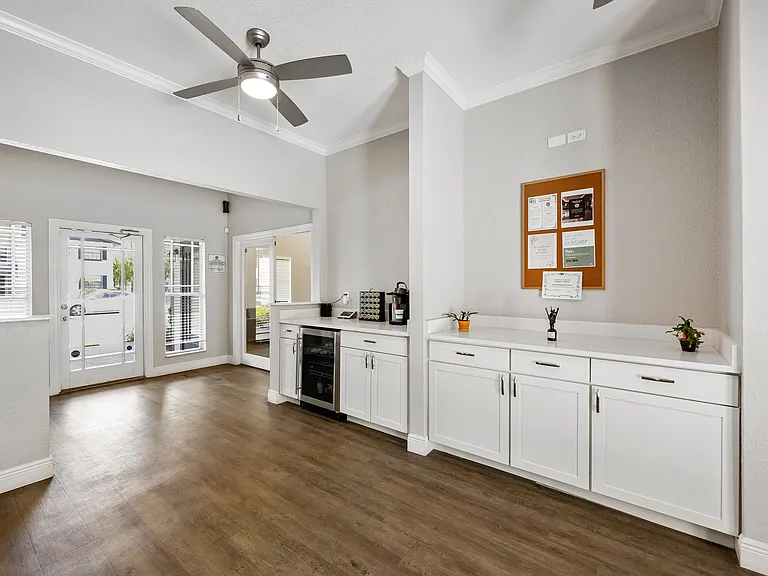 Bright and modern open-concept entryway featuring stylish cabinetry, sleek countertops, and elegant wood flooring, perfect for a welcoming living space.