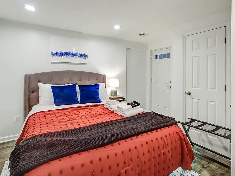 The first bedroom includes access to the rear staircase, which is primarily used for trash and recycling and serves as an additional emergency exit, with the patio at the top reserved for the upstairs residence.