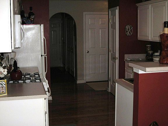 Kitchen features white cabinets, hardwood floors, gas stove
