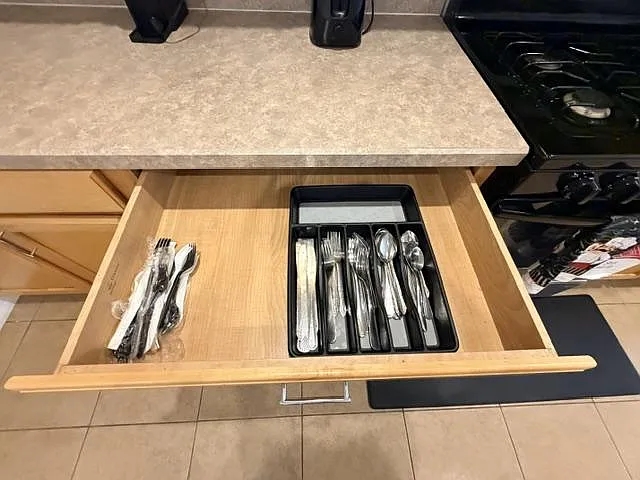 Kitchen drawer storage provides organized utensil space alongside countertop prep area and a gas cooktop for daily meals.