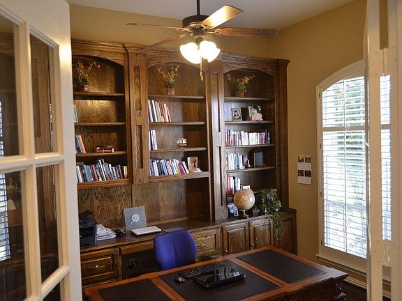 Just inside the front door is a study/library with built-in shelving and cabinetry and a window with plantation shutters facing the front garden. Home has French doors which lead to the study and wood flooring.