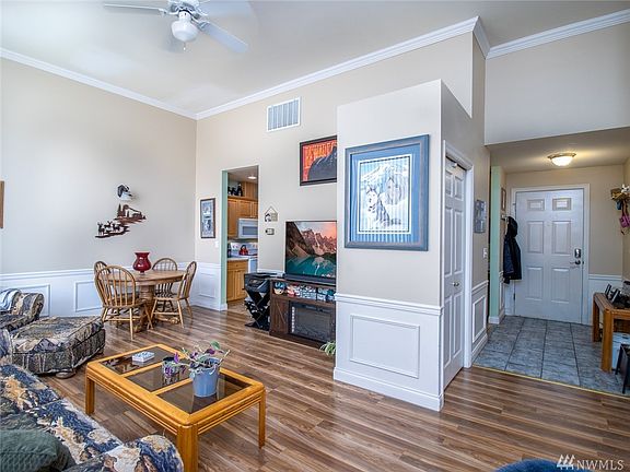 Living space & Dining area. Newer laminate wood plank flooring! Lovely wainscoting throughout.