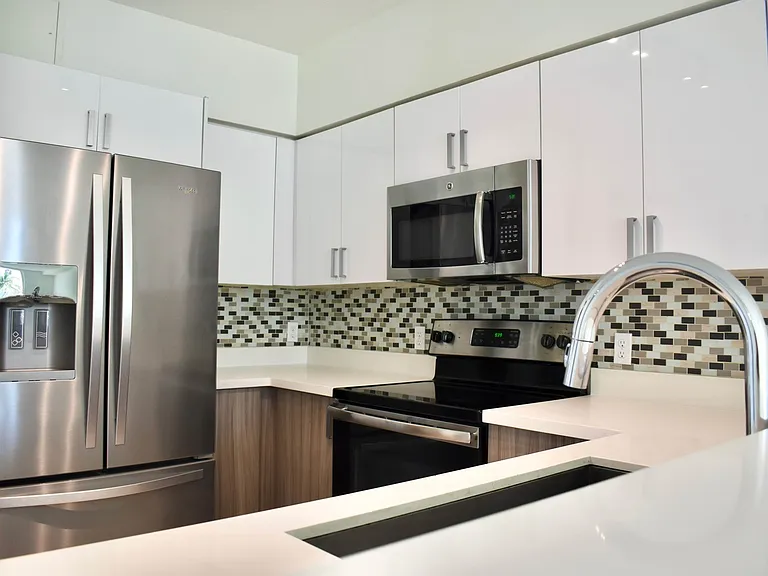 Quartz Countertops with Modern, White European-Style Cabinetry With Self-Closing Hinges & Designer Backsplash Tile