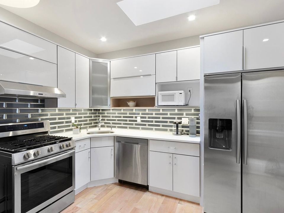 Modern kitchen with stainless steel applications, granite countertops, dishwasher, built in microwave, and spacious double door refrigerator