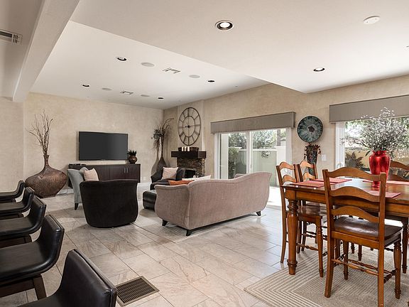 Reverse angle of Great Room; showing kitchen island dining, dining table and living room with 70" Large screen.
