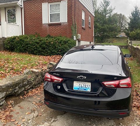 Side of house showing off street parking with extra parking in paved area for another vehicle. Fence to use if you wish
