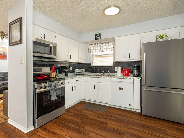 Modern kitchen with stainless steel appliances, all essentials, and easy backyard access for indoor-outdoor living.