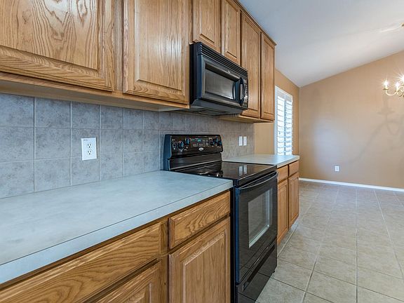The kitchen boasts a tile backsplash and an abundance of cabinets for plenty of storage.
