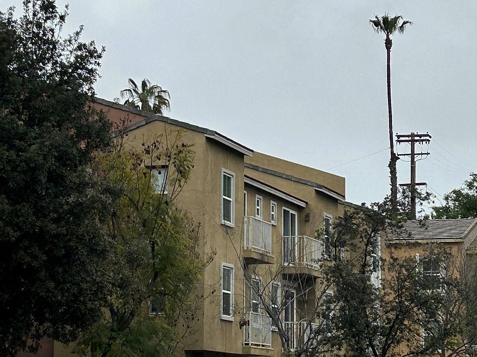 Fenced property around townhomes with attached garages and balconies at Serenata Townhomes in San Diego, California.