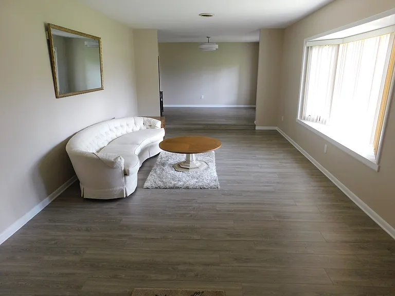 Just inside the entry doors to the right is the sunken living room, approximately 12.5' x 19.8'. The windows face east. Just beyond is the dining room where the hanging chandelier is.