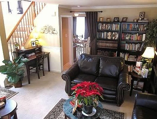 Living room facing kitchen and stairs with window opening to
