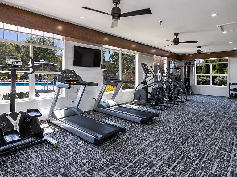 Our state-of-the-art fitness center offers a variety of equipment and a pool view to enhance your workout experience.