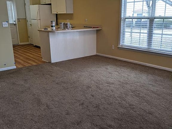Living room facing toward the large double windows near the eating area.
