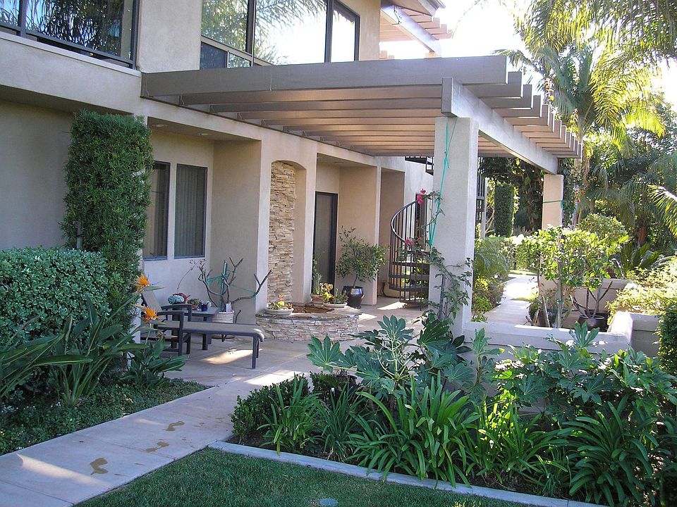 trellised patio with water feature & spiral staircase to deck