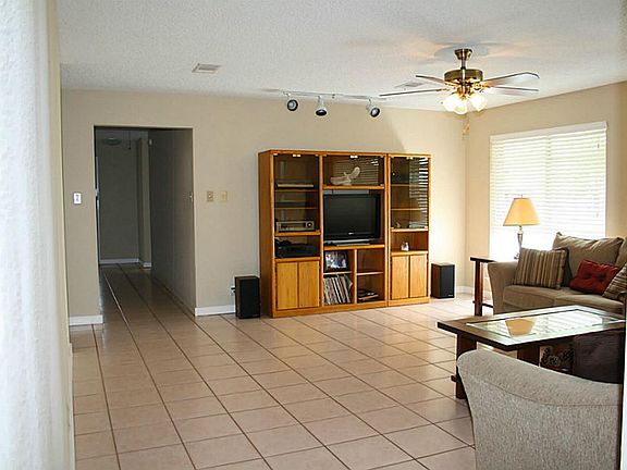 The living is VERY spacious, open and bright, with recessed lighting, track lighting, ceiling fan/light, 2 in blinds, and overlooks the ACREAGE in back.