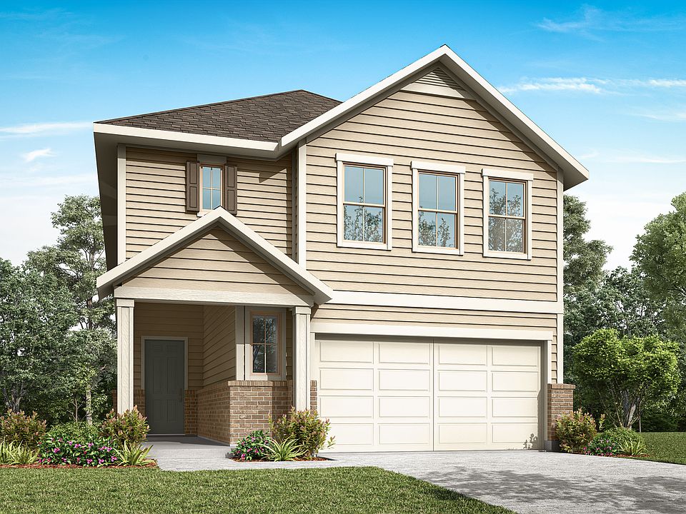 A two-story residential house with a garage, surrounded by lush greenery and a clear blue sky.