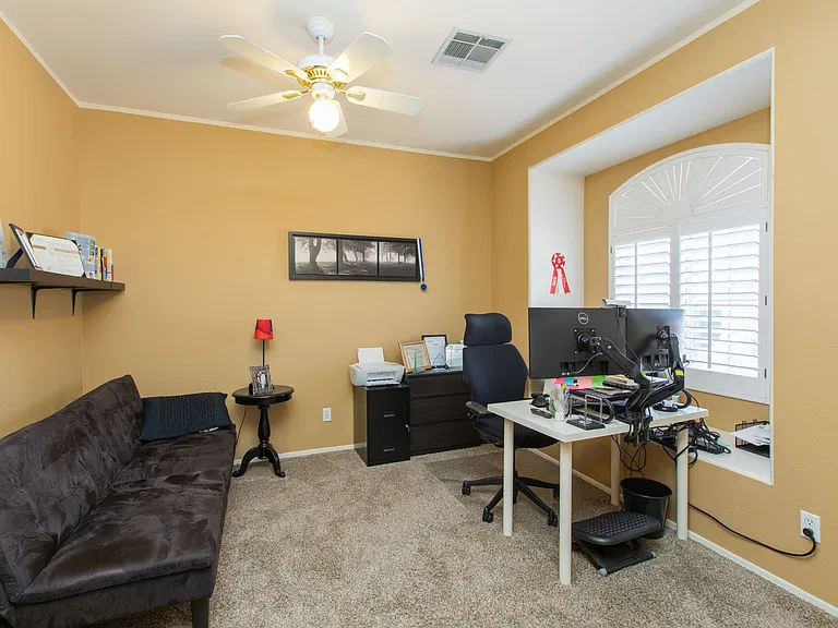 upstairs bedroom 3 featuring window bench & wood shutters, currently used as an office