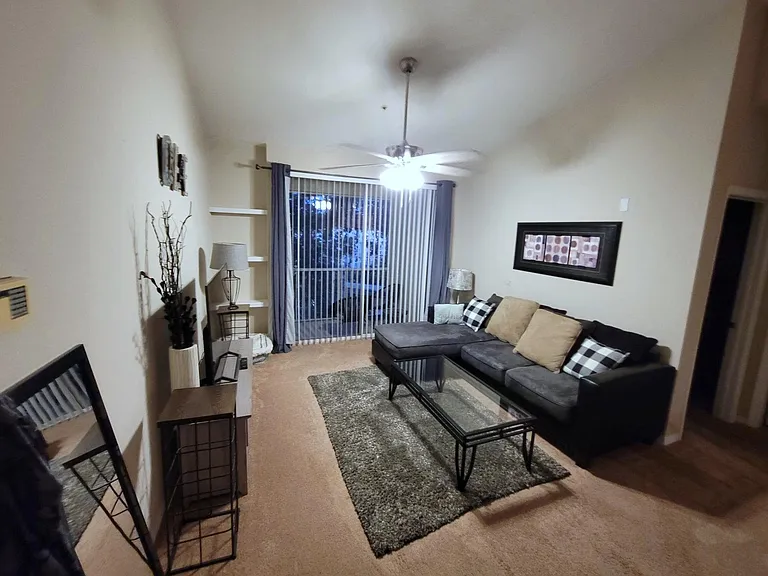 Cozy carpeted family room leading to balcony overlooking water & clubhouse.
