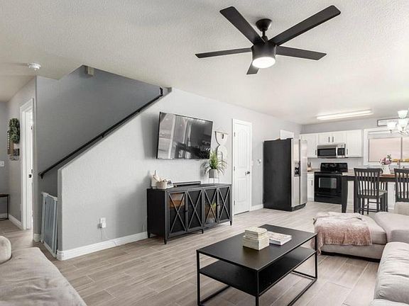 Living room with view of front door, door to half bath, and stairs.
