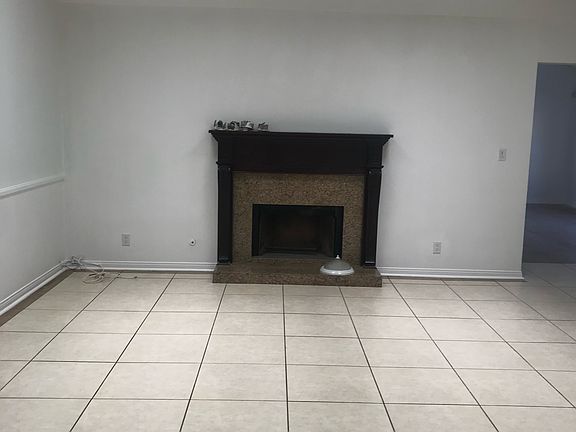 Well-lit living room with skylightd and fireplace.