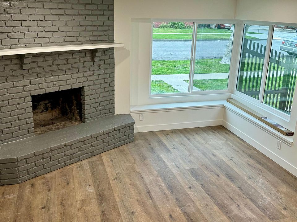 Spacious living room with double-paned picture windows and grand wood-burning fireplace.