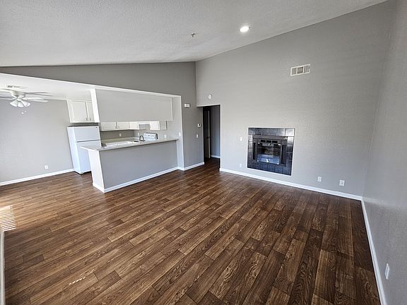 Livingroom with vaulted ceiling and gas fireplace. Large open floorplan with dining room and bar attached to kitchen.