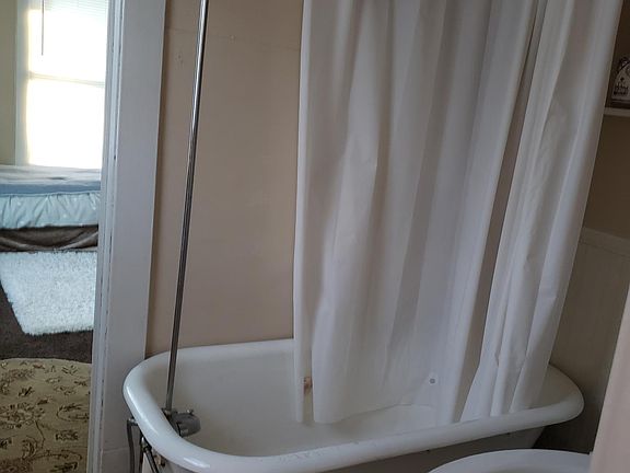 Bathroom showing claw foot bathtub with shower.